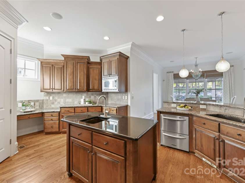 7295 Three Sisters Lane, Concord, NC 28027.  MLS# CAR4239485, YatesRealty ID 11233. Gourmet, Chef's Kitchen features granite counters, island, stainless steel appliances including double oven, gas cook top, tile back splash, desk area, walk in pantry & bar area!