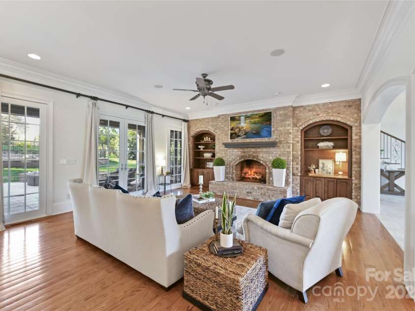 7295 Three Sisters Lane, Concord, NC 28027.  MLS# CAR4239485, YatesRealty ID 11233. Great Room offers beautiful, brick surround fireplace, custom built ins, crown molding, hardwood floors & access to your incredible Outdoor Living Area!