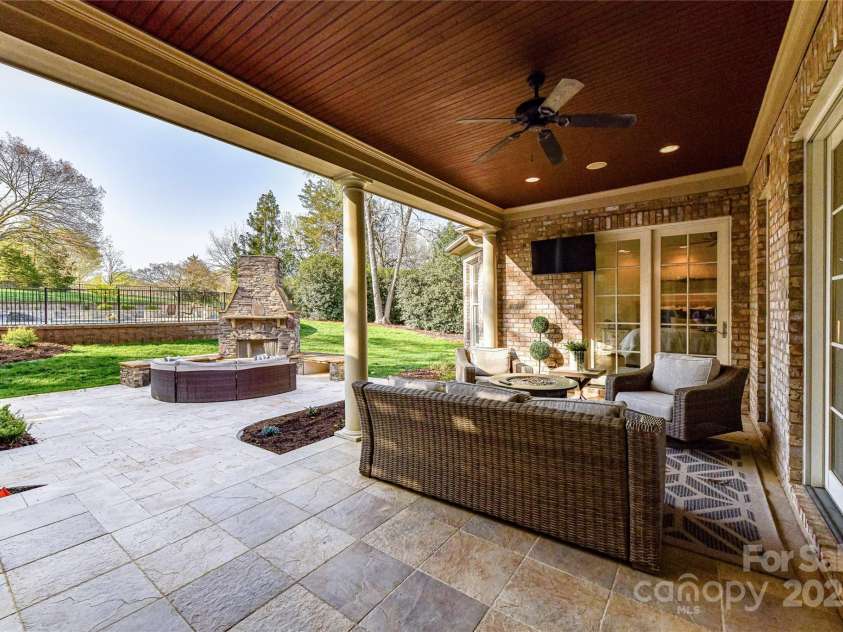 7295 Three Sisters Lane, Concord, NC 28027.  MLS# CAR4239485, YatesRealty ID 11233. Step out to your Covered Outdoor Paradise with ample seating area, outdoor fireplace & Pool/Spa!