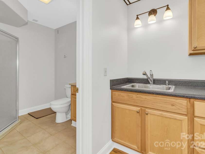 86 Distant View Drive, Asheville, NC 28803.  MLS# CAR4299899, YatesRealty ID 11339. 3rd level down massive rec room. Could be wood shop, game room with plents of space for a pool table or convert into a movie room complete with it's on bathroom. 