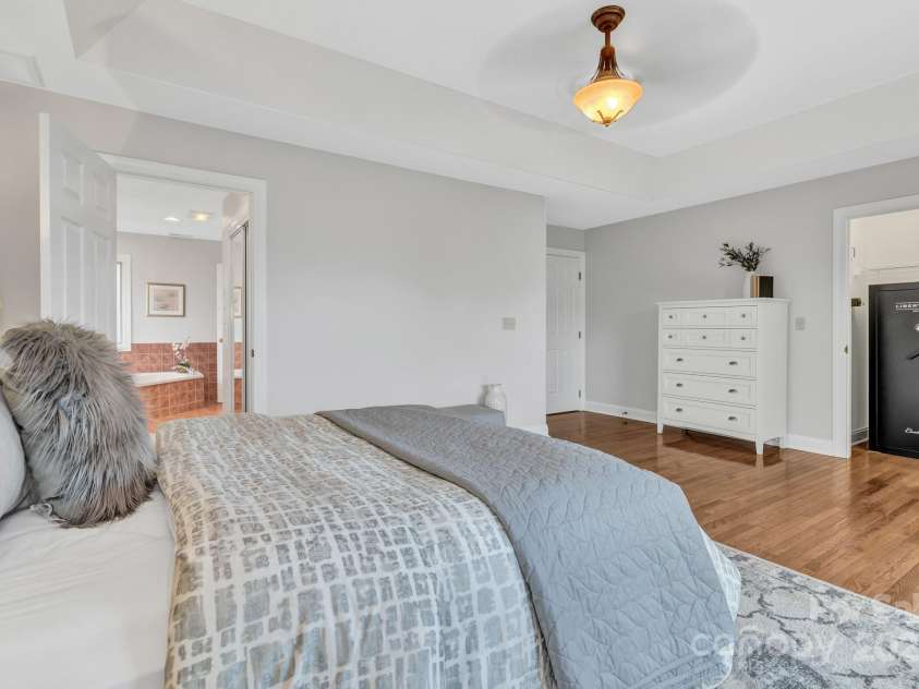 86 Distant View Drive, Asheville, NC 28803.  MLS# CAR4299899, YatesRealty ID 11339. Primary bedroom on the main level with french doors leading to a 3 season room. 