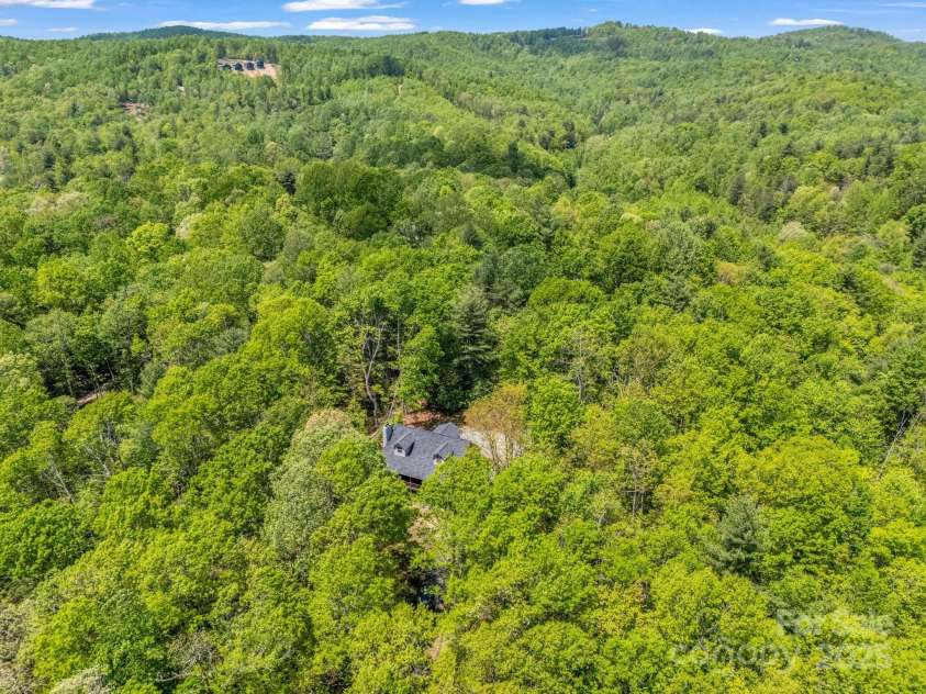 2304 Mountain Page Road, Saluda, NC 28773.  MLS# CAR4246121, YatesRealty ID 11346. Aerial view of lush green and mountains in the distance