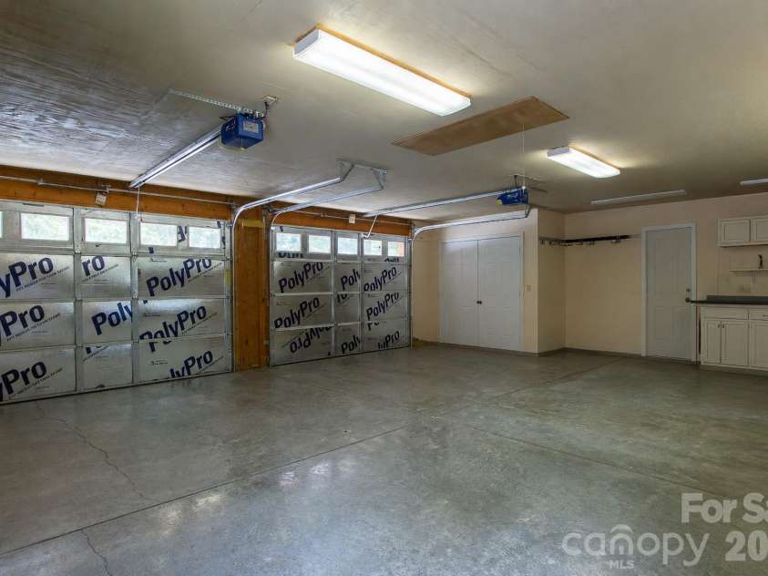 153 Brandy Ridge, Brevard, NC 28712.  MLS# CAR4366624, YatesRealty ID 11352. Expansive Garage InteriorWell-lit garage interior offers exceptional space for multiple vehicles, tools, recreational equipment, and workshop activities.