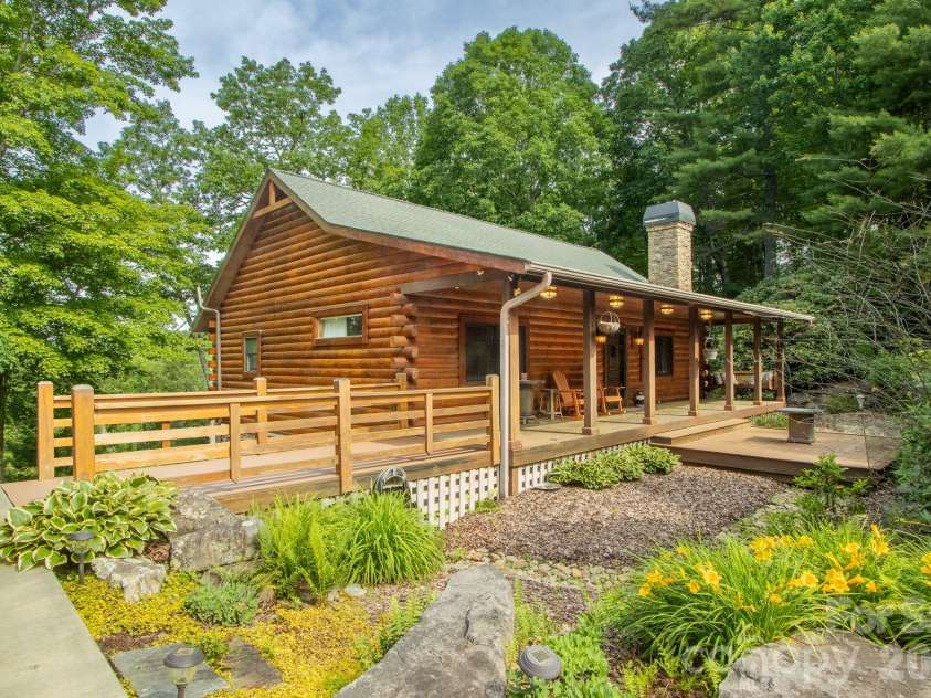 153 Brandy Ridge, Brevard, NC 28712.  MLS# CAR4366624, YatesRealty ID 11352. Front Exterior & LandscapingPicturesque front elevation featuring extensive decking, colorful landscaping, and timeless log-home architecture nestled within a serene mountain environment.