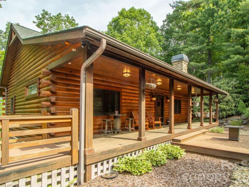 153 Brandy Ridge, Brevard, NC 28712.  MLS# CAR4366624, YatesRealty ID 11352. Front Porch & Entry ApproachInviting front elevation highlighting the covered porch, rich log construction, and beautifully maintained outdoor living spaces that create immediate curb appeal.