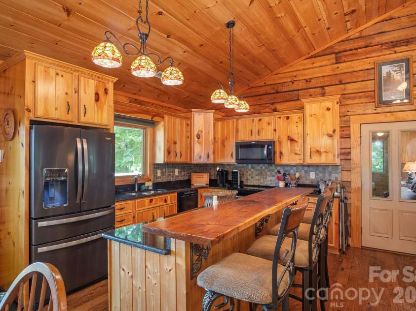 153 Brandy Ridge, Brevard, NC 28712.  MLS# CAR4366624, YatesRealty ID 11352. Kitchen & Breakfast BarWell-appointed kitchen featuring custom wood cabinetry, granite countertops, stainless steel appliances, and an oversized breakfast bar ideal for casual dining and entertaining.