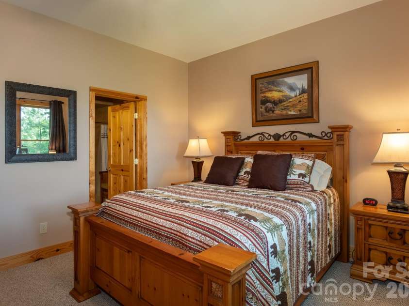 153 Brandy Ridge, Brevard, NC 28712.  MLS# CAR4366624, YatesRealty ID 11352. Lower-Level Ensuite BedroomInviting guest suite featuring private bath access, ample natural light, and mountain-lodge character.