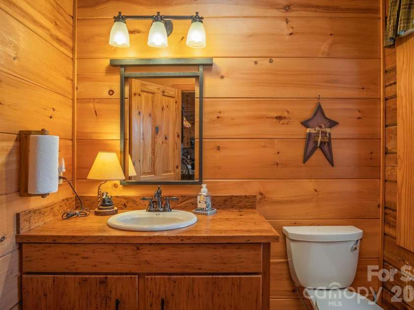 153 Brandy Ridge, Brevard, NC 28712.  MLS# CAR4366624, YatesRealty ID 11352. Main-Level Half BathConvenient main-level powder room featuring rustic wood finishes, custom vanity, and natural light that complements the home's warm mountain character.