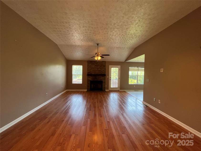 37 Woodridge View Court, Hendersonville, NC 28791.  MLS# CAR4255791, YatesRealty ID 11369. Living room with vaulted ceilings and stone mantle surrounding the fireplace