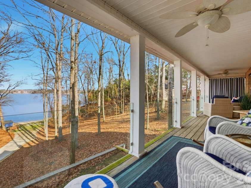 4737 Betty Davis Drive, York, SC 29745.  MLS# CAR4342456, YatesRealty ID 11374. The back porch has been enhanced with glass panels, creating unobstructed views of the lake while maintaining safety and clean sightlines. Whether seated or standing, the water remains the focal point.