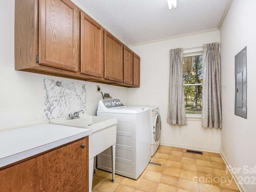 240 Partridge Run, Salisbury, NC 28147.  MLS# CAR4305095, YatesRealty ID 11401. A dedicated laundry room, with lots of cabinets, a folding area, and a pull down ironing board just out of camera range.