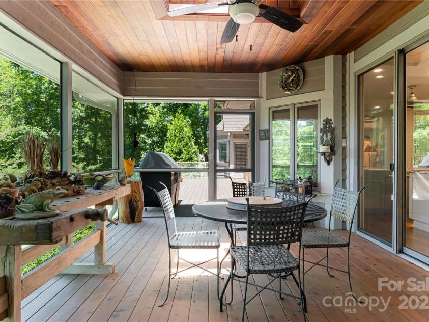 57 Old Hickory Trail, Hendersonville, NC 28739.  MLS# CAR4150896, YatesRealty ID 115. A skylight and rich wood paneling make this screen porch the ideal space to entertain