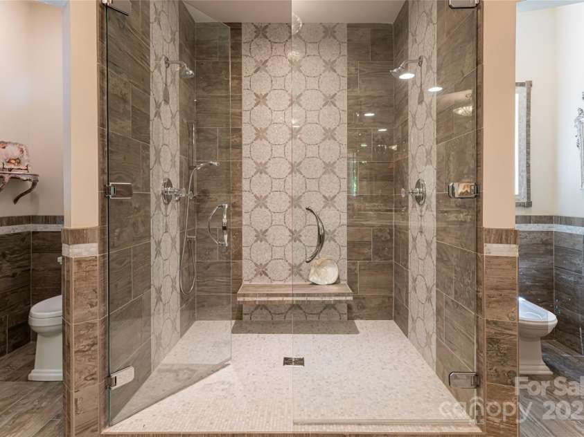 57 Old Hickory Trail, Hendersonville, NC 28739.  MLS# CAR4150896, YatesRealty ID 115. The primary bath centers around a stunning walk-in tile shower