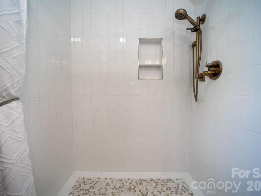 216 Tinequa Drive, Brevard, NC 28712.  MLS# CAR4365636, YatesRealty ID 11539. Custom-tiled walk in shower with grab bar