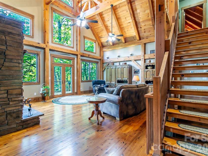 58 Great Aspen Way, Black Mountain, NC 28711.  MLS# CAR4366858, YatesRealty ID 11545. Looking from the foyer into the light-filled living room with its wood-burning fireplace and vaulted ceiling.