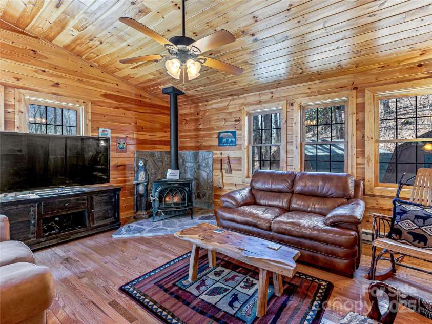 71 Honeymoon Lane, Maggie Valley, NC 28751.  MLS# CAR4240026, YatesRealty ID 11581. Den with wood burning pot belly firpelace.