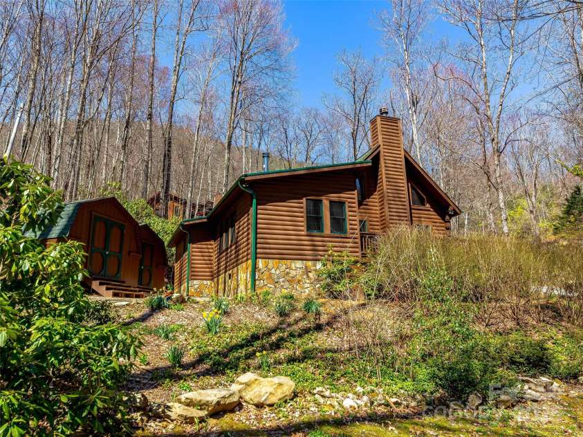 71 Honeymoon Lane, Maggie Valley, NC 28751.  MLS# CAR4240026, YatesRealty ID 11581. Viewing the den side of the home from below also with the two powered sheds in the back