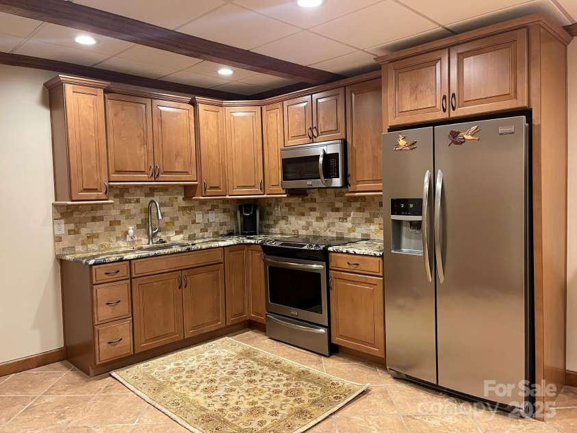 377 Riverwood Road, Mooresville, NC 28117.  MLS# CAR4192992, YatesRealty ID 11616. Basement kitchen has 42