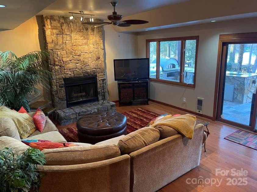 377 Riverwood Road, Mooresville, NC 28117.  MLS# CAR4192992, YatesRealty ID 11616. Basement living area features gas stone fireplace and tray ceiling.