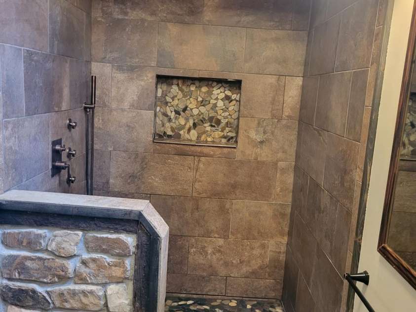 377 Riverwood Road, Mooresville, NC 28117.  MLS# CAR4192992, YatesRealty ID 11616. Primary bath features rustic stone, tile, RR tie look with stone floor & cut-out.