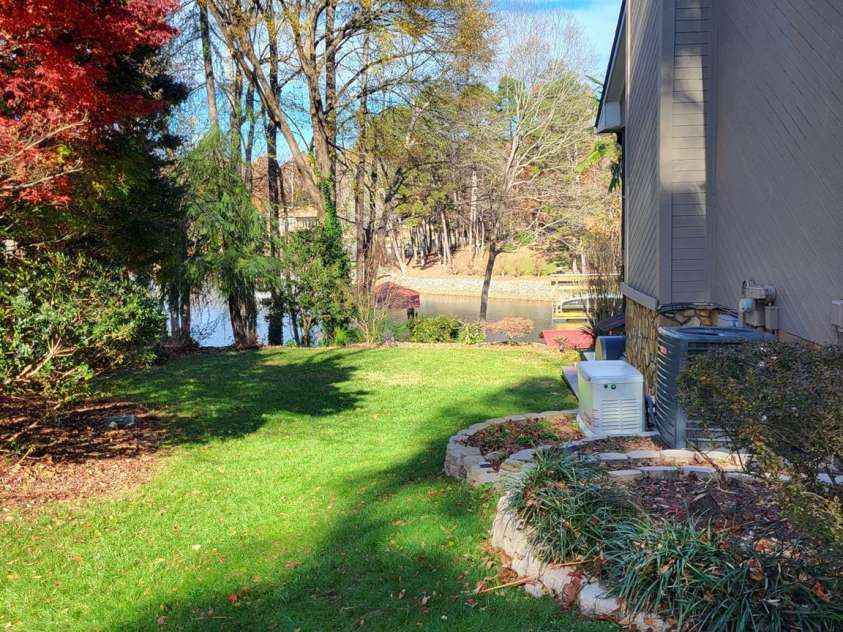 377 Riverwood Road, Mooresville, NC 28117.  MLS# CAR4192992, YatesRealty ID 11616. View from side of home...grass has just been reseeded and everything is in bloom!