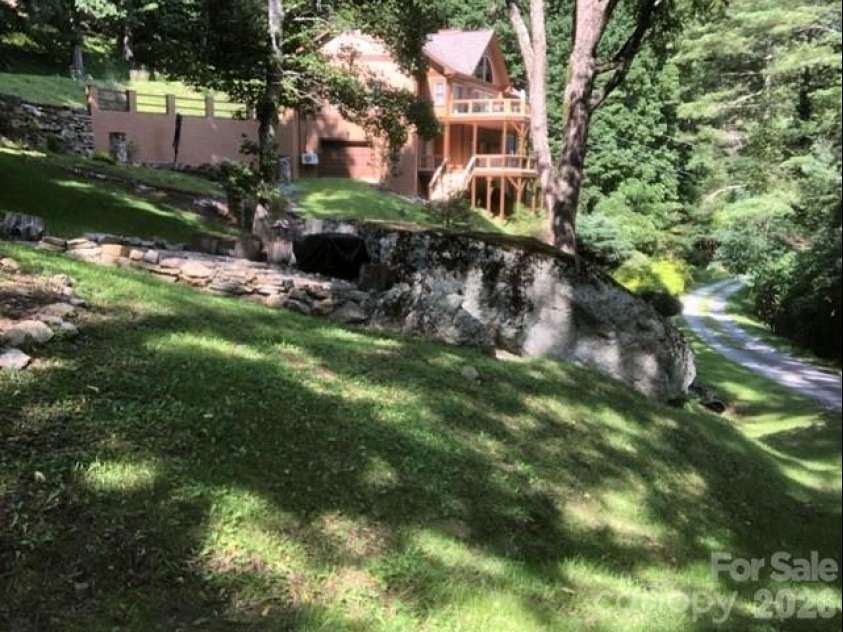 446 Windridge Drive, Sugar Grove, NC 28679.  MLS# CAR4360975, YatesRealty ID 11618. Beautiful grounds accented by huge rock . This view shows the second lower level garage currently use for storage but has key pad and auto door opener.