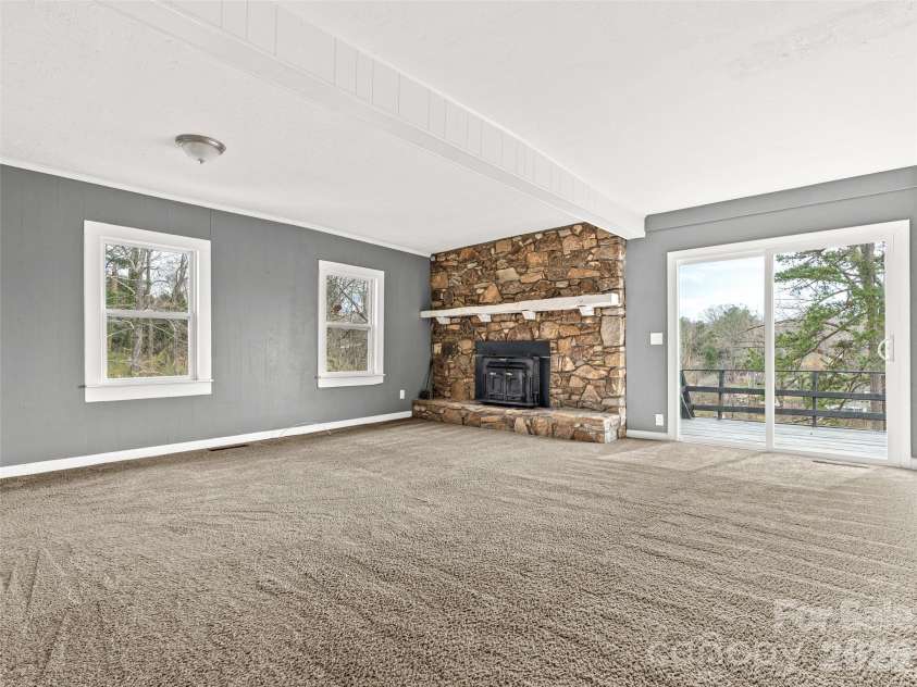 15 Woodbine Road, Asheville, NC 28804.  MLS# CAR4360828, YatesRealty ID 11619. Large living room with stone hearth. 