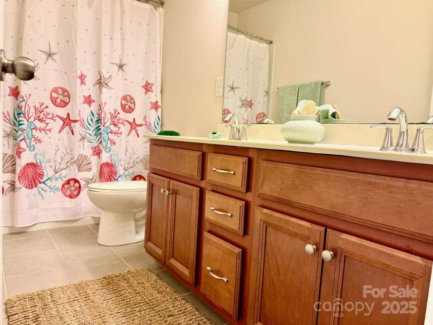 121 Mackinac Drive, Mooresville, NC 28117.  MLS# CAR4218931, YatesRealty ID 11674. Upstairs full bathroom with tile floors and cherrywood cabinets. Sparkling chrome fixtures.