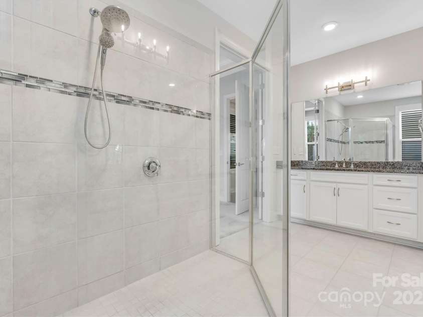 8210 Festival Way, Charlotte, NC 28215.  MLS# CAR4324351, YatesRealty ID 11707. Dual vanities, overhead & handheld shower combo, and a custom closet—your private sanctuary awaits.