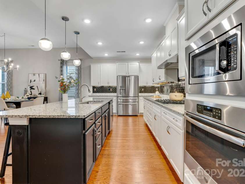 8210 Festival Way, Charlotte, NC 28215.  MLS# CAR4324351, YatesRealty ID 11707. This stunning kitchen is perfect for morning coffee to dinner parties - spacious island, wall ovens, stainless steel appliance package and a walk-in pantry!