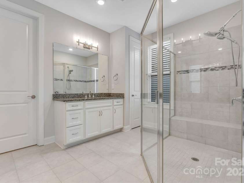 8210 Festival Way, Charlotte, NC 28215.  MLS# CAR4324351, YatesRealty ID 11707. Wind down at the end of your day in luxury - dual vanities, walk-in tile shower with bench, and a custom closet for all your treasures.