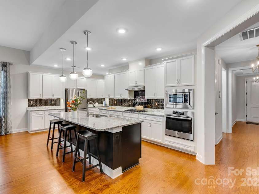 8210 Festival Way, Charlotte, NC 28215.  MLS# CAR4324351, YatesRealty ID 11707. Your dream kitchen awaits: gas cooktop, wall ovens, under-cabinet lighting, and seamless flow to the living area