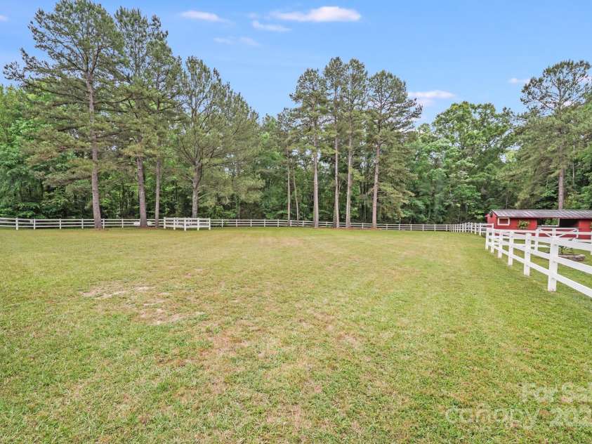 6910 Birdsong Lane, Waxhaw, NC 28173.  MLS# CAR4253788, YatesRealty ID 11745. Mature pastureland stretches across the property, enclosed by classic white fencing that enhances both function and curb appeal