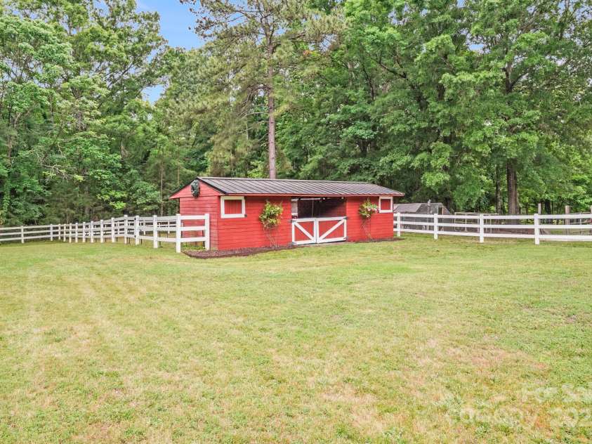 6910 Birdsong Lane, Waxhaw, NC 28173.  MLS# CAR4253788, YatesRealty ID 11745. Two stall barn with a center storage, a private paddock and a large mature pasture