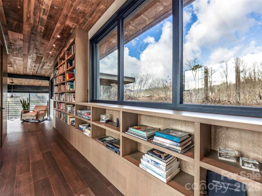 112 Moon Shadow Lane, Marshall, NC 28753.  MLS# CAR4332984, YatesRealty ID 1175. Custom bookshelves line the hall between the two upper areas, overlooking the living roof.