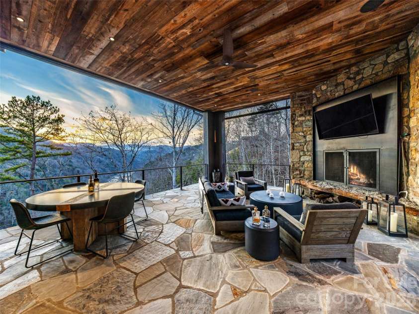 112 Moon Shadow Lane, Marshall, NC 28753.  MLS# CAR4332984, YatesRealty ID 1175. Enjoy the fire while cheering on your favorite team on TV! Hemlock ceilings, stone floors, and steel beams, set the stage for this outdoor oasis.