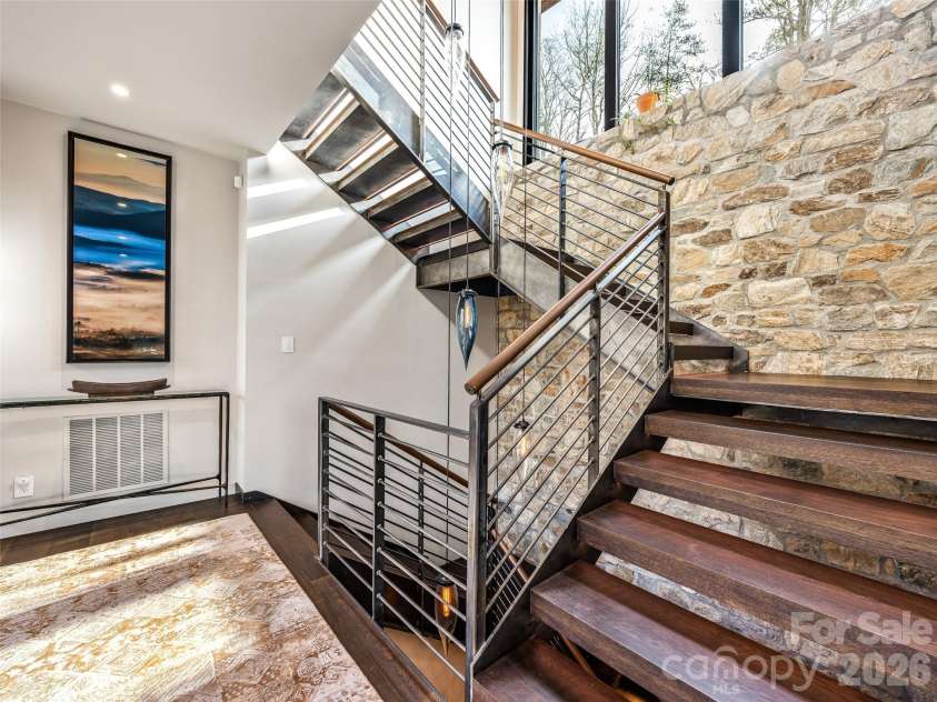 112 Moon Shadow Lane, Marshall, NC 28753.  MLS# CAR4332984, YatesRealty ID 1175. Entryway full of natural light has floating stairs with rock accents and leather wrapped handrails.