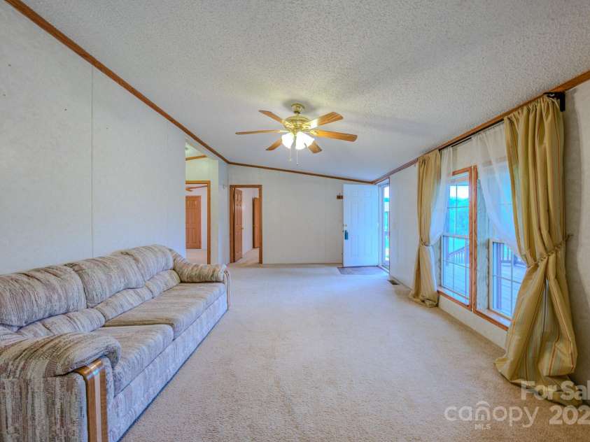 22 Hominy Baptist Church Road, Candler, NC 28715.  MLS# CAR4255118, YatesRealty ID 11853. Living Room view of front door and Primary bedroom entrance