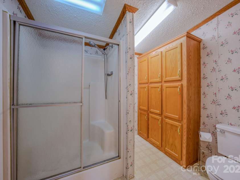 22 Hominy Baptist Church Road, Candler, NC 28715.  MLS# CAR4255118, YatesRealty ID 11853. Primary shower with extra storage