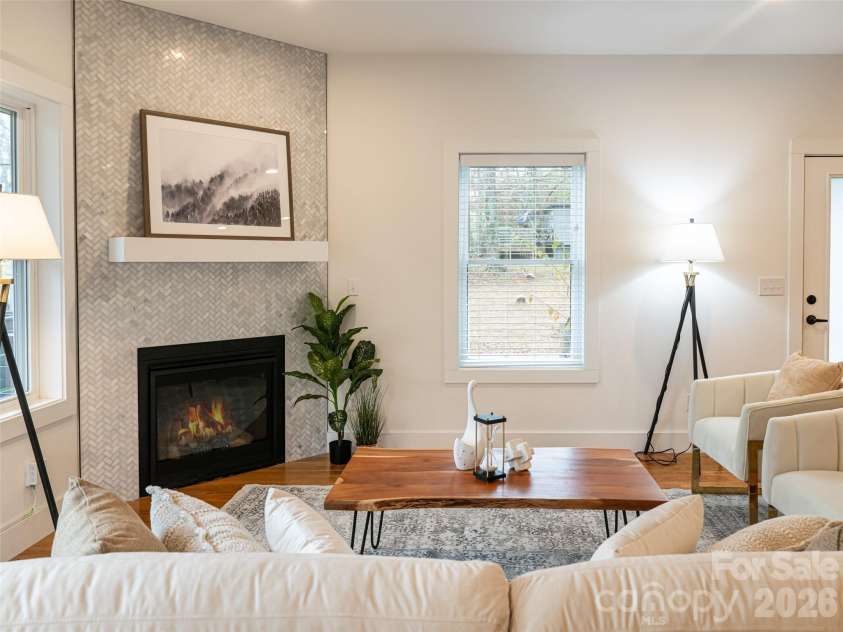 197 Chatham Road, Asheville, NC 28804.  MLS# CAR4290361, YatesRealty ID 11880. Cozy gas fireplace with marble surrounding. Room for a large TV or lovely artwork. Natural light from multiple windows fill the room