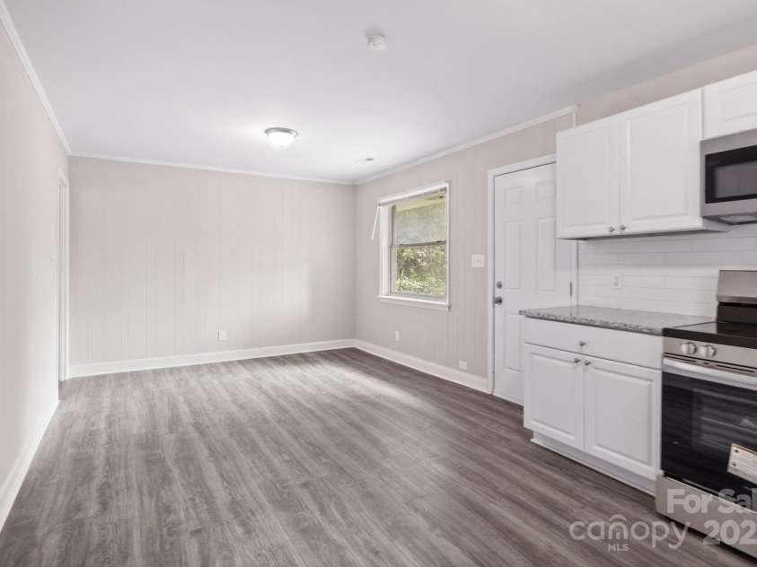 816 Echo Glen Road, Charlotte, NC 28213.  MLS# CAR4248212, YatesRealty ID 11891. Partial shot of kitchen, with emphasis on dining area (empty space in center of photo). On the left opens back to the hallway that connects the remainder of the home and the living room. Door pictured on the right goes 