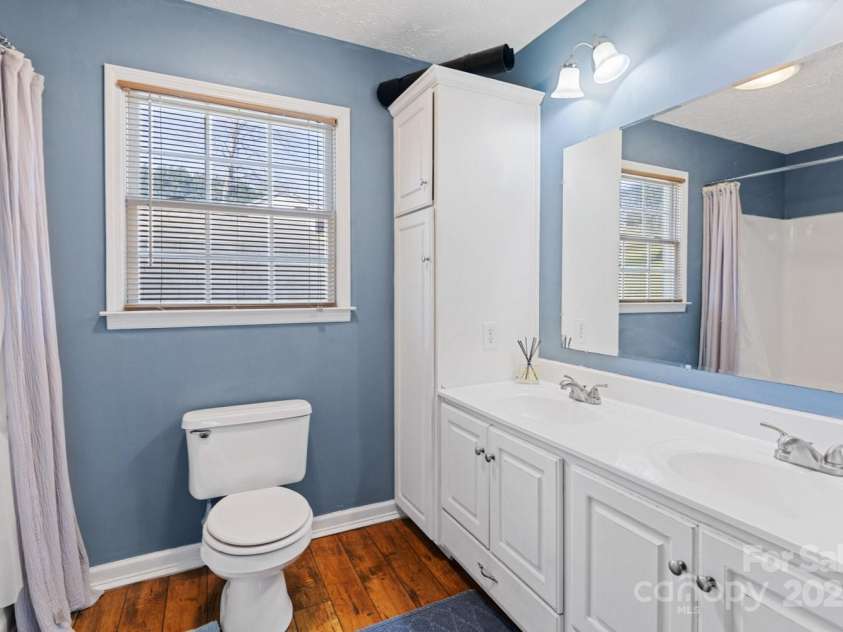 122 Ramsey Road, Asheville, NC 28806.  MLS# CAR4233927, YatesRealty ID 12010. Downstairs bathroom complete with double sinks, a large soaking tub, and a walk-in closet.