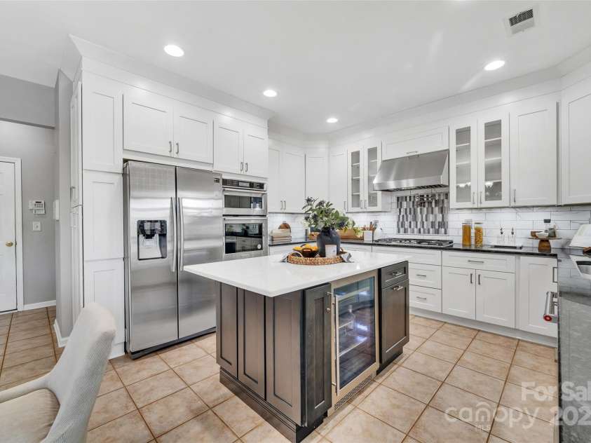 5412 Fulton Ridge Drive, Indian Trail, NC 28079.  MLS# CAR4237895, YatesRealty ID 12017. Completely remodeled chef's kitchen with beverage fridge in island. Two toned granite countertops are a perfect foil for the white cabinetry and stainless appliances.