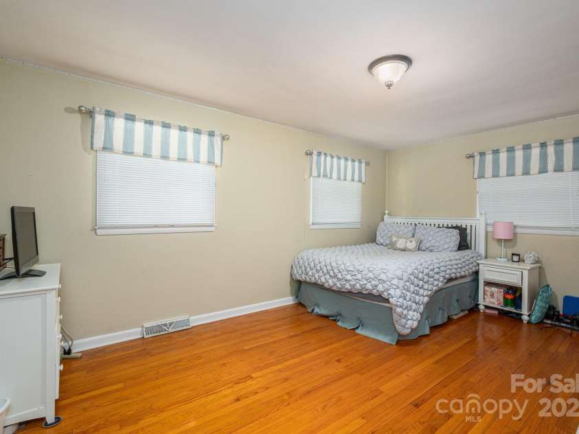 227 Country Club Circle, Shelby, NC 28150.  MLS# CAR4256011, YatesRealty ID 12032. On the other side of kitchen is the first bedroom with neutral colors, natural light and wood floors.