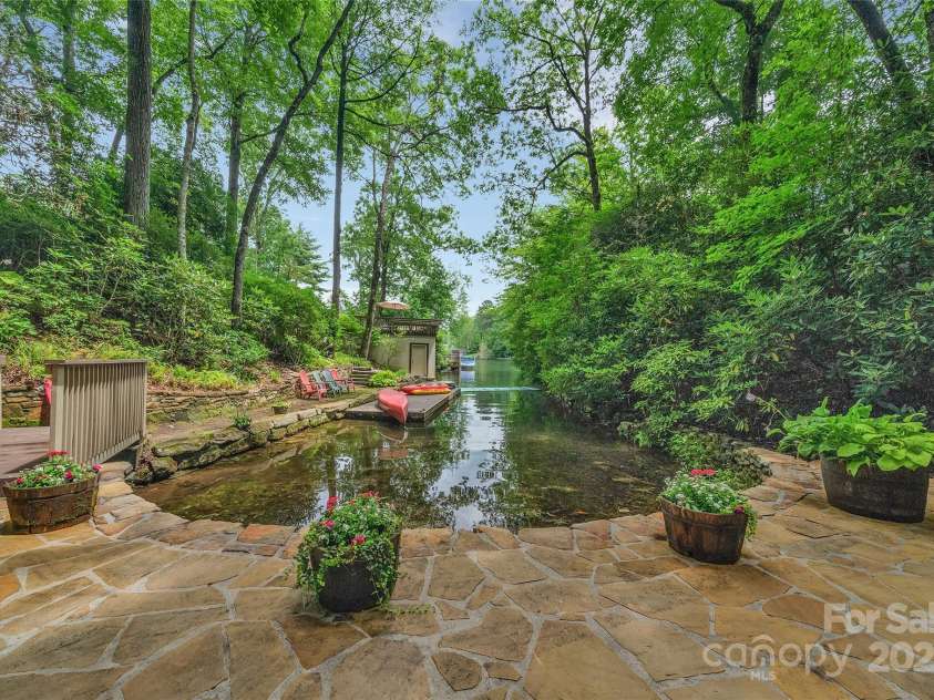 562 West Club Boulevard, Lake Toxaway, NC 28747.  MLS# CAR4199636, YatesRealty ID 1207. Extensive stone patio overlooking the lake