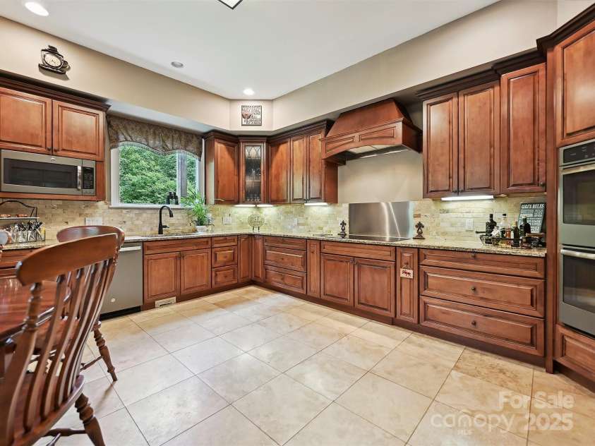 1140 Fern Hill Road, Mooresville, NC 28117.  MLS# CAR4255290, YatesRealty ID 12085. Open kitchen on main level with so many features, included breakfast area, tile floors, accent lighting.