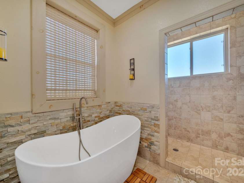 246 Pinnacle Mountain Road, Zirconia, NC 28790.  MLS# CAR4249618, YatesRealty ID 12104. Beautiful soaking tub in primary ensuite bath, walk-in tiled shower