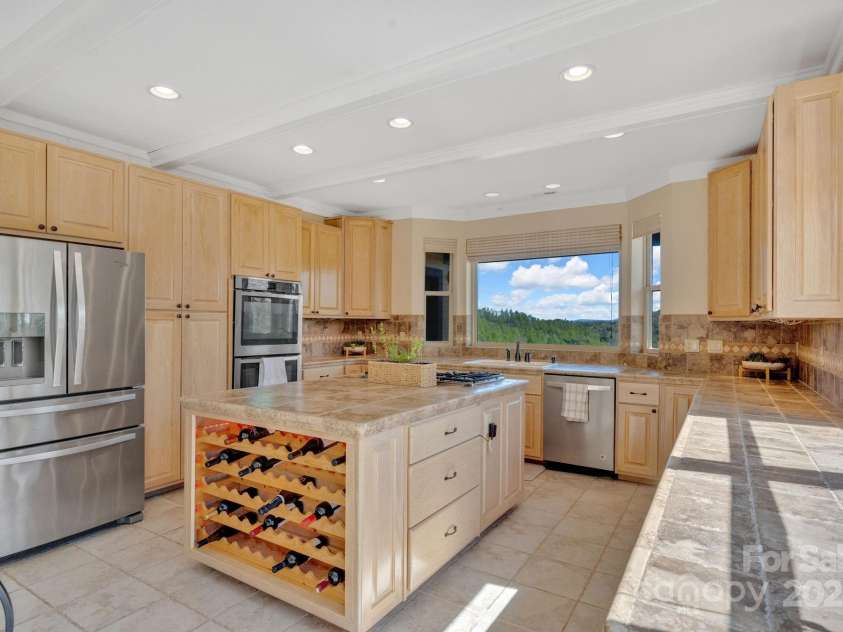 246 Pinnacle Mountain Road, Zirconia, NC 28790.  MLS# CAR4249618, YatesRealty ID 12104. Chef's kitchen with large island and built-in wine rack, stainless steel appliances