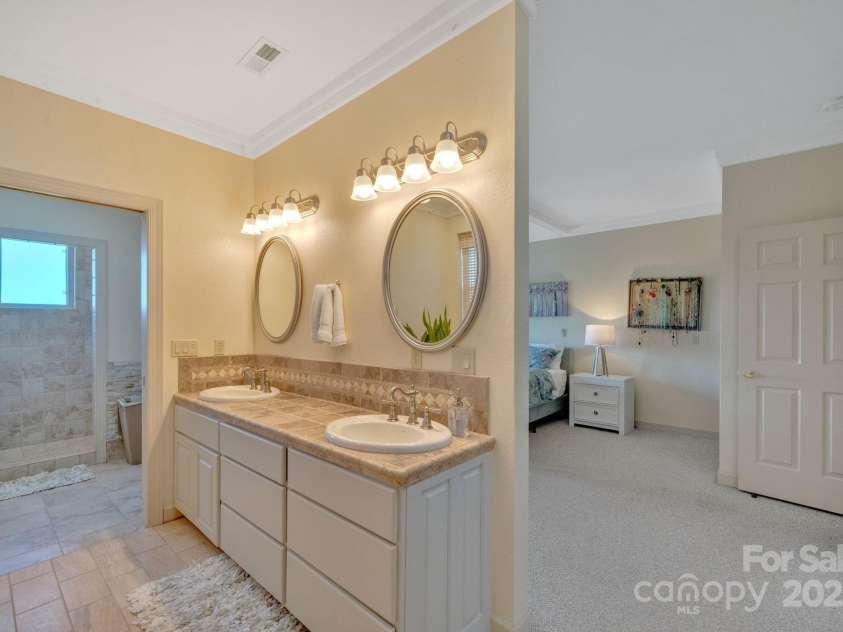 246 Pinnacle Mountain Road, Zirconia, NC 28790.  MLS# CAR4249618, YatesRealty ID 12104. Double vaniety sinks, walk-in tiled shower in primary bathroom