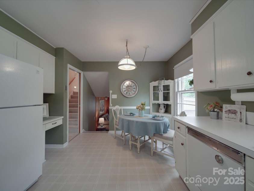 2213 Milton Road, Charlotte, NC 28215.  MLS# CAR4255190, YatesRealty ID 12108. Long view of kitchen showcases built in desk to right of the refrigerator